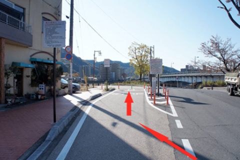 Turn left at the road in the photo and stop at the green parking barrier.